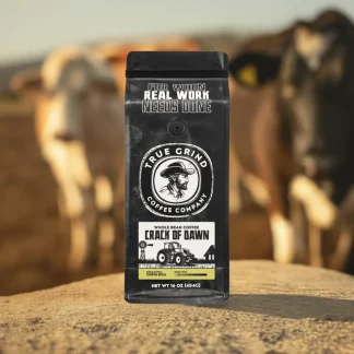 Bag of Crack of Dawn coffee featured in a cattle farm scene.